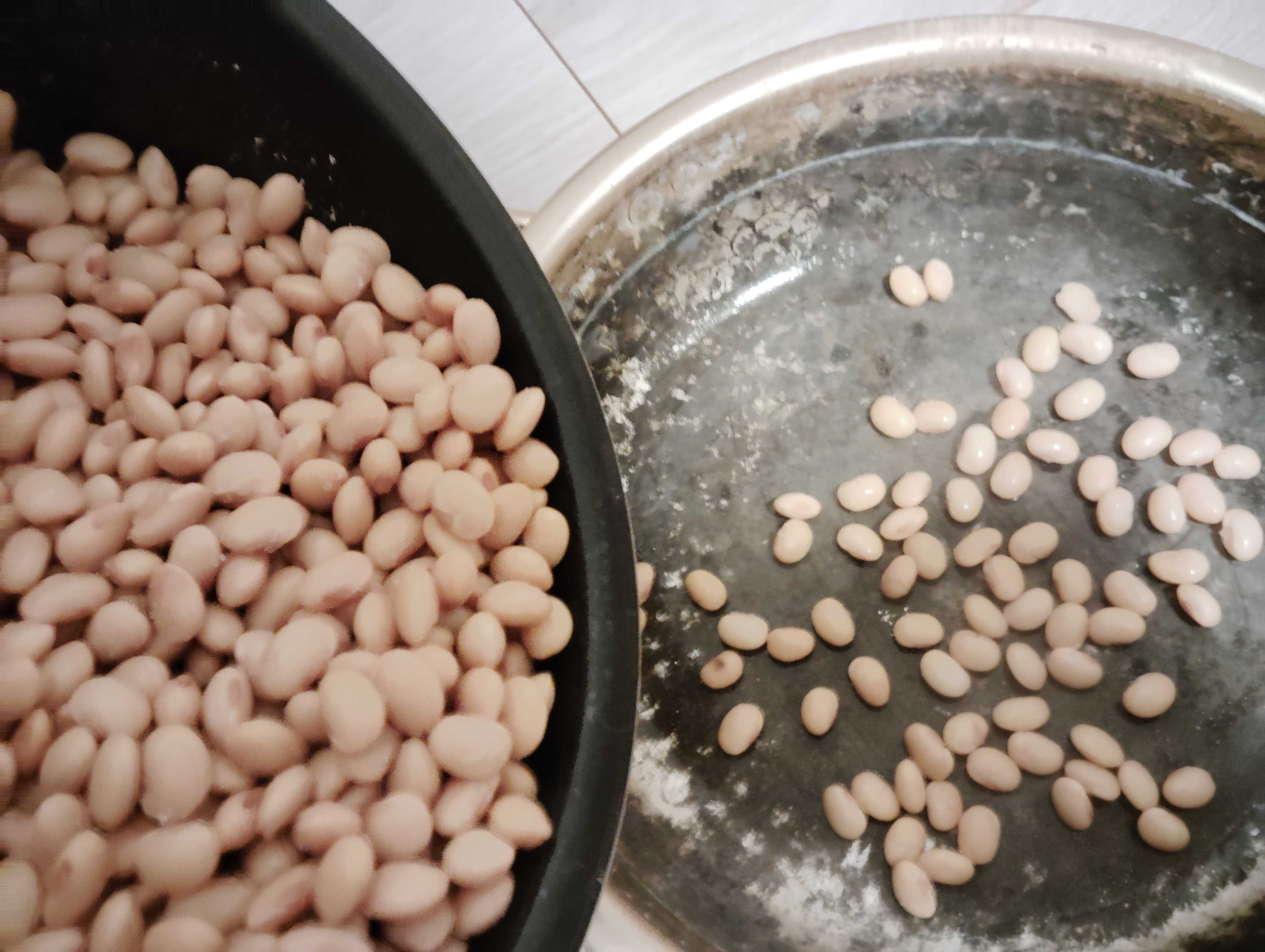 茹でた豆をアルミ鍋によそう